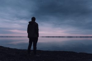 Silhouette of a man standing on a cliff contemplating how to use fear to his advantage and achieve success