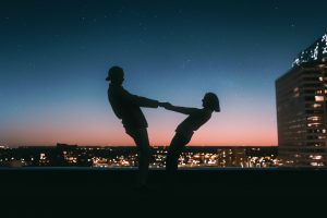 Happy couple silhouette dancing on a rooftop